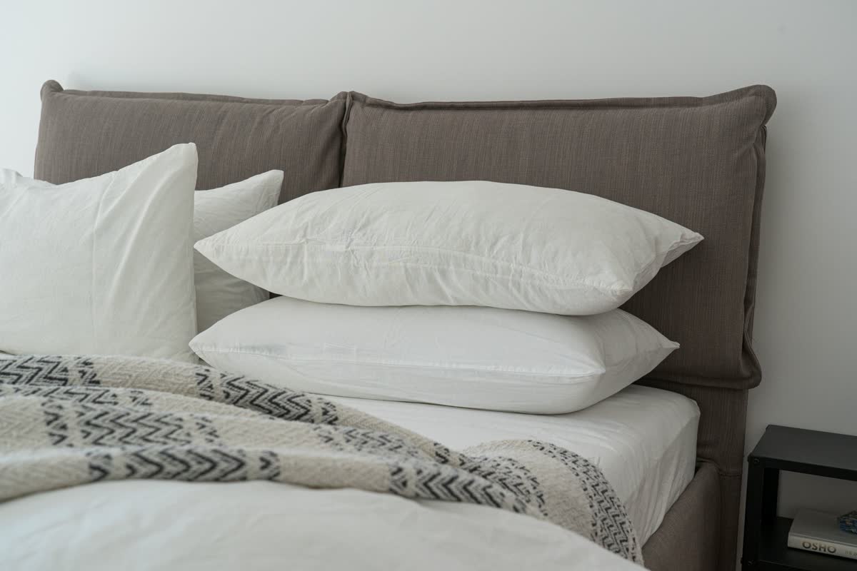 A made bed with pillows and soft bedding