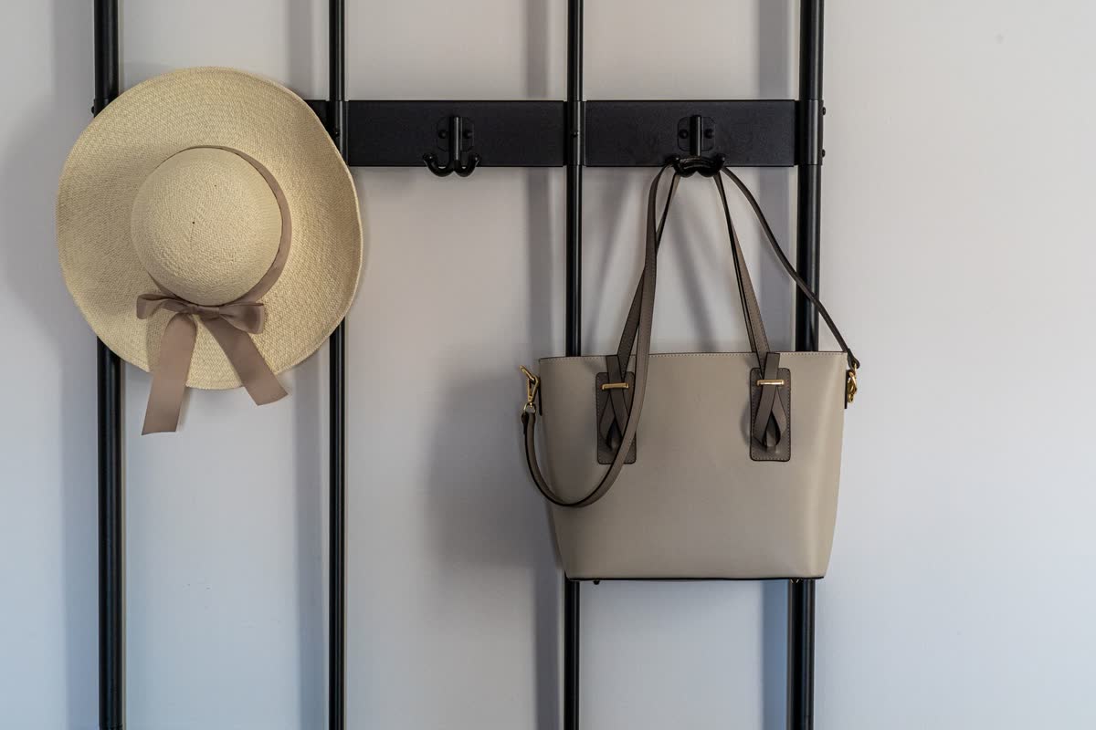Bags and a hat hanging on wall hooks