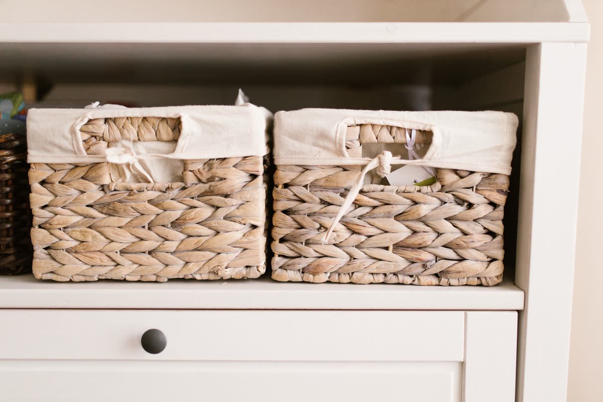 Two labeled woven baskets on a console